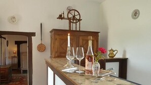 A kitchen counter with a marble top, a wooden cabinet, a candle, a bottle, and a vase with flowers. - Outbuilding of a listed 16th-century château (Château-sur-Allier)