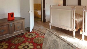 A bedroom with a four-poster bed, a wooden dresser, and a red bag on the dresser. - Outbuilding of a listed 16th-century château (Château-sur-Allier)