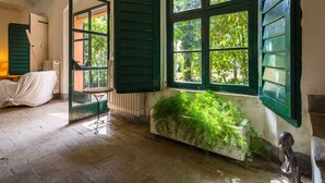 Una habitación con un radiador, una silla tapizada y una estatua.