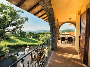 Une terrasse avec des places assises extérieures, une architecture en pierre et une vue sur la campagne.