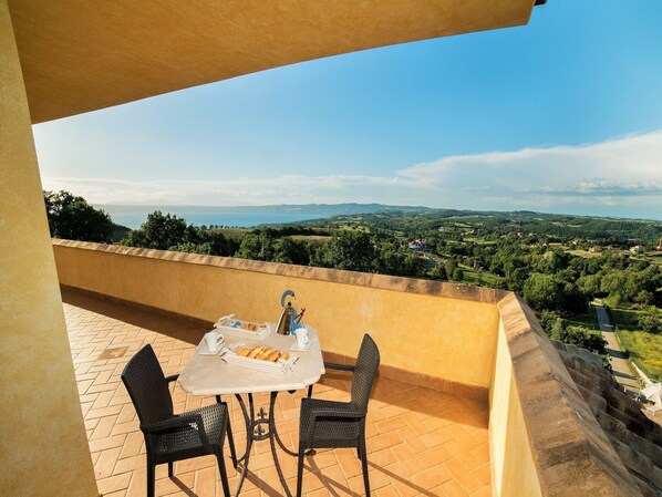 Une terrasse avec une table et des chaises donnant sur un paysage magnifique.