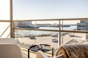 A room with a large window overlooking a marina with boats and a dock. - Modern Apartment in Den Haag (Den Haag)
