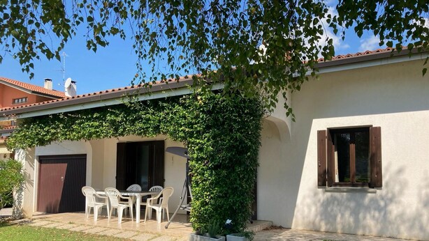 A house with a patio, a covered seating area, and a garden. - Villa in Northern Italy near Borgo di Toppo (Travesio)