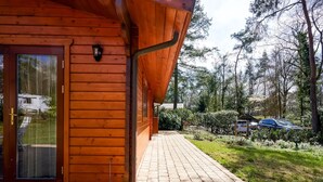 Une cabane en bois avec un chemin pavé menant à une porte en verre.
