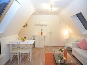 En moderne loftlejlighed med spiseplads, køkken og opholdsstue.