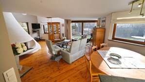 A spacious living room with a sofa, armchairs, and a dining table. - Lodge in Ardennes near La Roche Center (LA ROCHE EN ARDENNES)