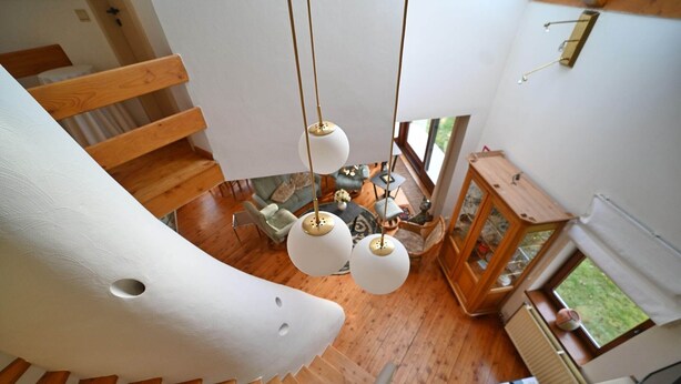 A modern interior with a wooden staircase, hanging spherical light fixtures, and a view of a garden through a window. - Lodge in Ardennes near La Roche Center (LA ROCHE EN ARDENNES)