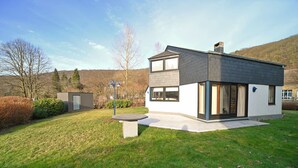 A modern two-story house with a flat roof, large windows, and a well-maintained lawn. - Lodge in Ardennes near La Roche Center (LA ROCHE EN ARDENNES)