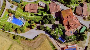 Vista aérea de una zona residencial con varias casas, una piscina y paneles solares.