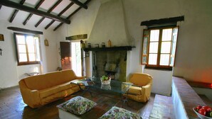A cozy living room with a wooden ceiling, a sofa, a coffee table, and a fireplace.