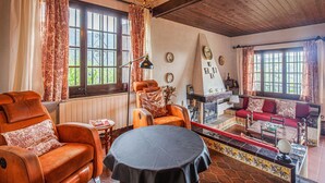 A cozy living room with leather sofas, a fireplace, and a view of the outdoors.