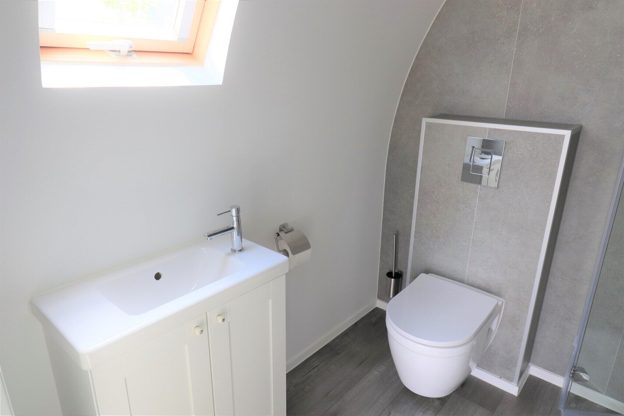 A bathroom with a white sink, toilet, and shower.