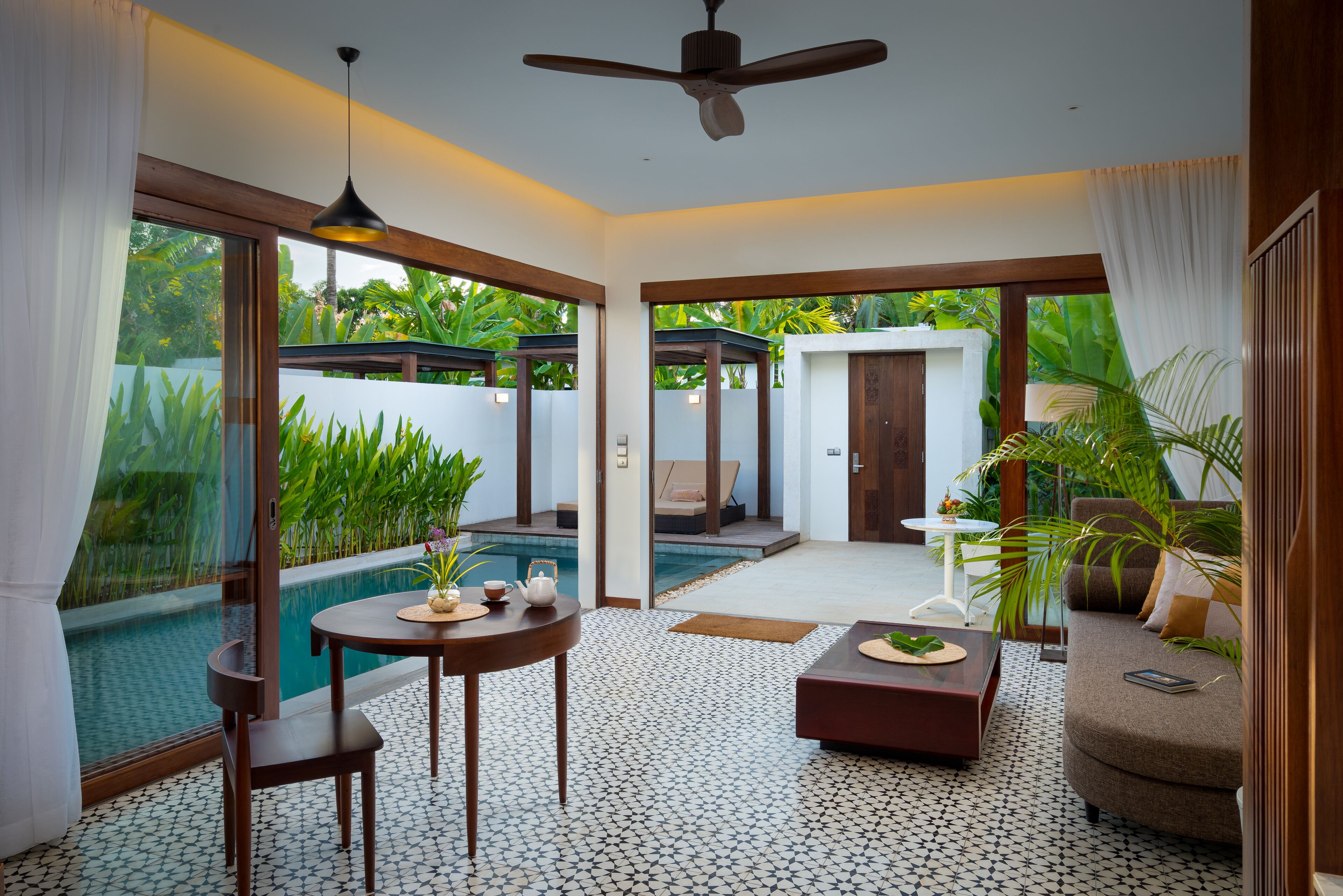 A spacious living area with a pool, a ceiling fan, and a view of the outdoors.