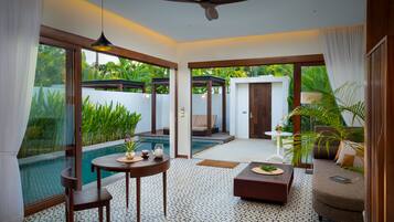 A spacious living area with a pool, a ceiling fan, and a view of the outdoors.