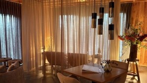 Ein Essbereich mit einem Holztisch, Stühlen und einer Blumenvase.