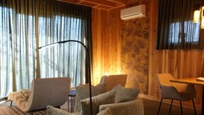 Ein Zimmer mit Holzwand, Deckenventilator, Tisch und Stuhl.
