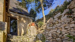 A stone staircase leading to a rustic building with a wooden door and a window.