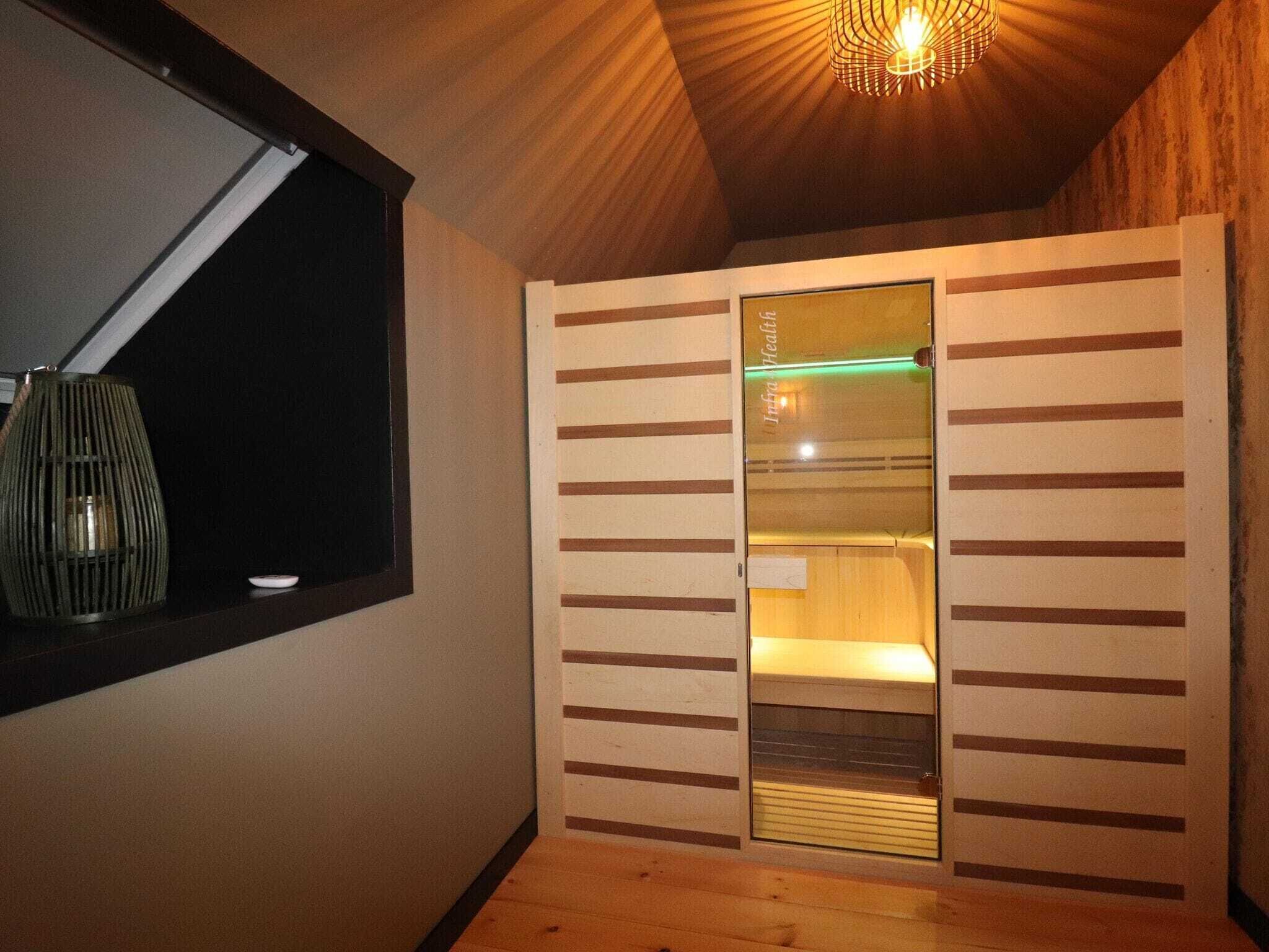 A room with a wooden ceiling, a window with a view, and a sliding door with a sign that reads "Infra Health."