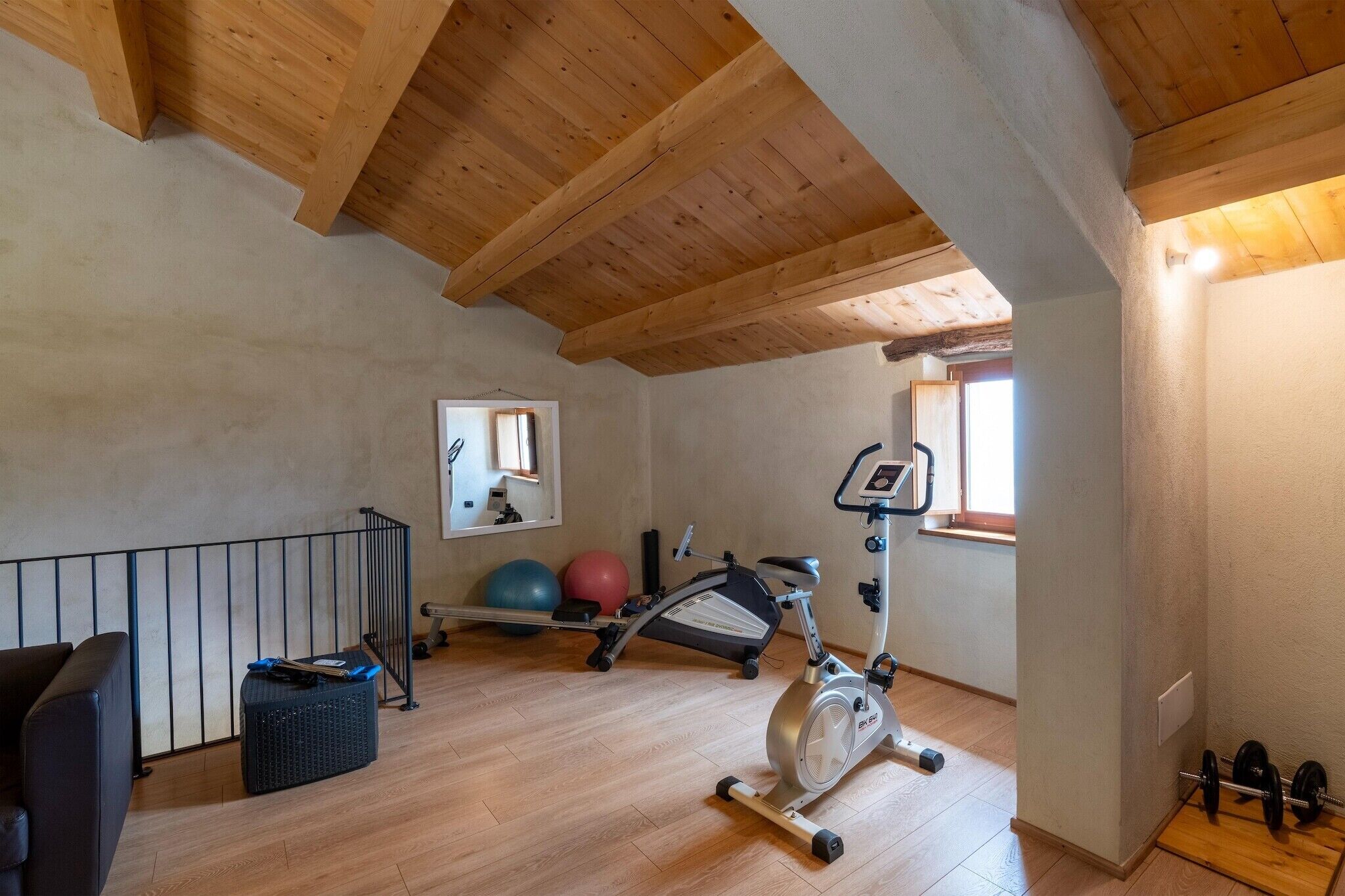 A gym with exercise equipment, a mirror, and a window.