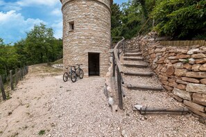 A stone tower with a door and a staircase leading up to it. - Country House with Saltwater Pool (Acqualagna)
