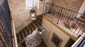 A staircase with a wrought iron railing, a radiator, and a floral-patterned bench. - Holiday Home in Fano near Adriatic Sea (Fano)