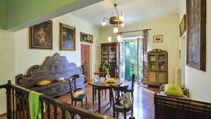 Un salón amplio con un sofá grande, una mesa de comedor y una escalera que sube a otro nivel.