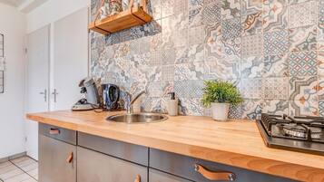 Een kookplaat, een koffiezetapparaat/waterkoker, eettafels