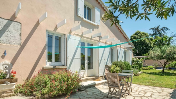 A house with a stone patio, a small garden, and a table with chairs. - Pretty holiday home with garden and hot tub (Bédoin)