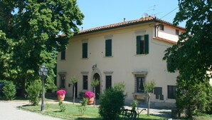 A two-story building with a tiled roof, green shutters, and a central entrance with an archway. - Villa Life in Vicchio; the Tuskan way (Vicchio)
