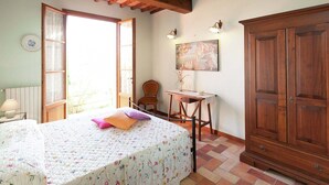 Une chambre à coucher comprenant un lit, un bureau, une chaise et une armoire.