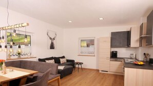 Eine moderne Wohnung mit Essbereich, Sofa, Küche und Wohnzimmer.