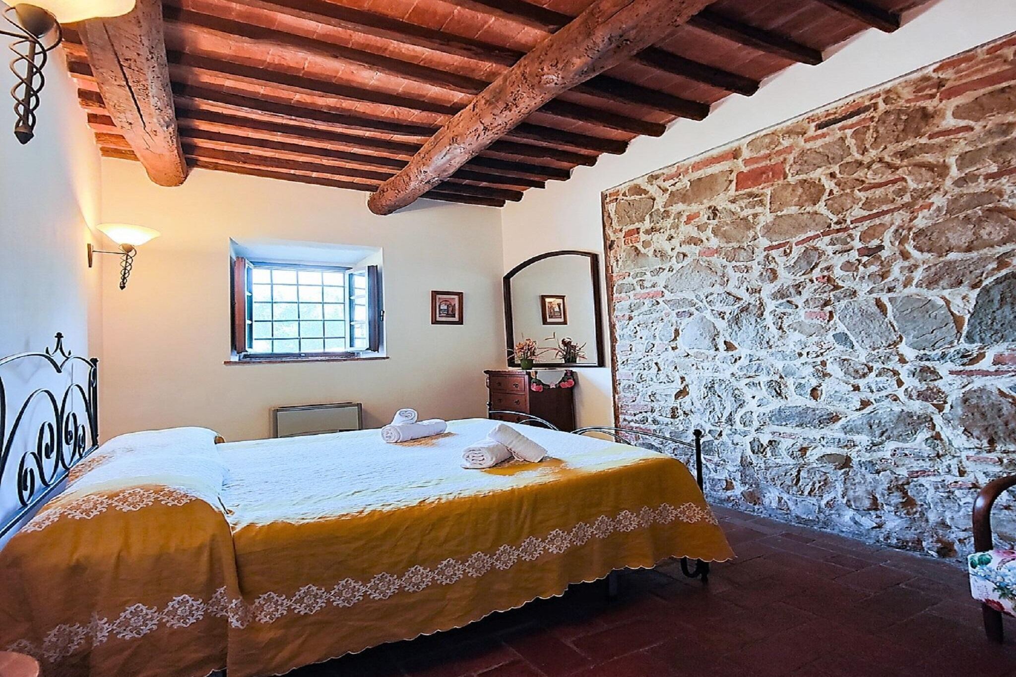 Une chambre à coucher avec un lit, une fenêtre, un mur en pierre et un plafond en bois.