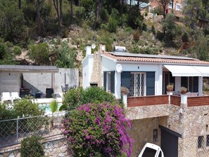 Ein modernes Haus mit Naturstein-Fassade, einem Pool und einer Terrassenfläche.
