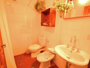 Un baño con inodoro, bidé y lavabo.