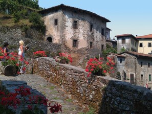 Un edificio de piedra de aspecto rústico, con una pared de piedra y una ventana pequeña.