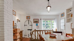A rustic dining area with a wooden table and chairs, a hanging light fixture, and a view of the outdoors through a window. - Idyllic Retreat with shared pool (Migliorini - Pistoia)