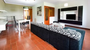A modern living room with a sofa, TV, and dining area. - Stay in Historic Laguardia, Sleeps 8 (Laguardia)