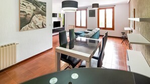 A modern living room with a dining area, large windows, and a painting on the wall. - Stay in Historic Laguardia, Sleeps 8 (Laguardia)