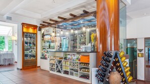 A wine shop with shelves of bottles, a display of wine glasses, and a large wooden column. - Countryside home in Foligno (Foligno)