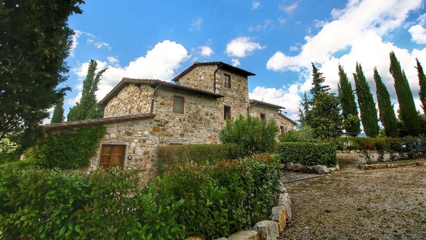 A stone building with a sloped roof, surrounded by greenery and trees. - Apartment in Radda with Garden (Radda in Chianti)
