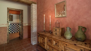 A room with a wooden cabinet, a mirror, and two vases.