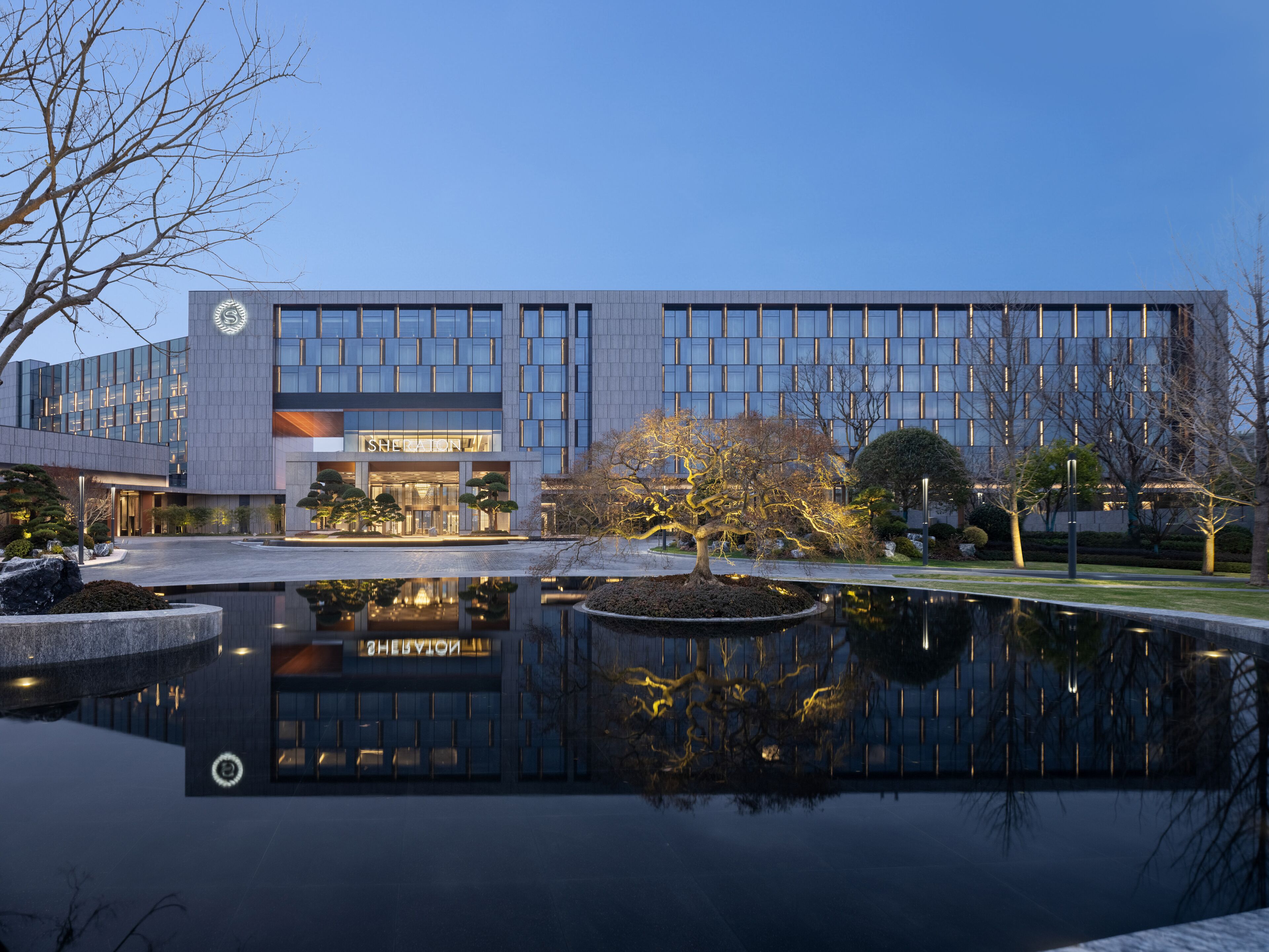 A modern building with a reflective pool and well-maintained landscaping.