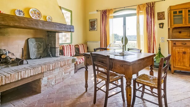 A rustic dining area with a stone bench, wooden table, and chairs. - Belvilla by OYO Lenze (Staffoli)