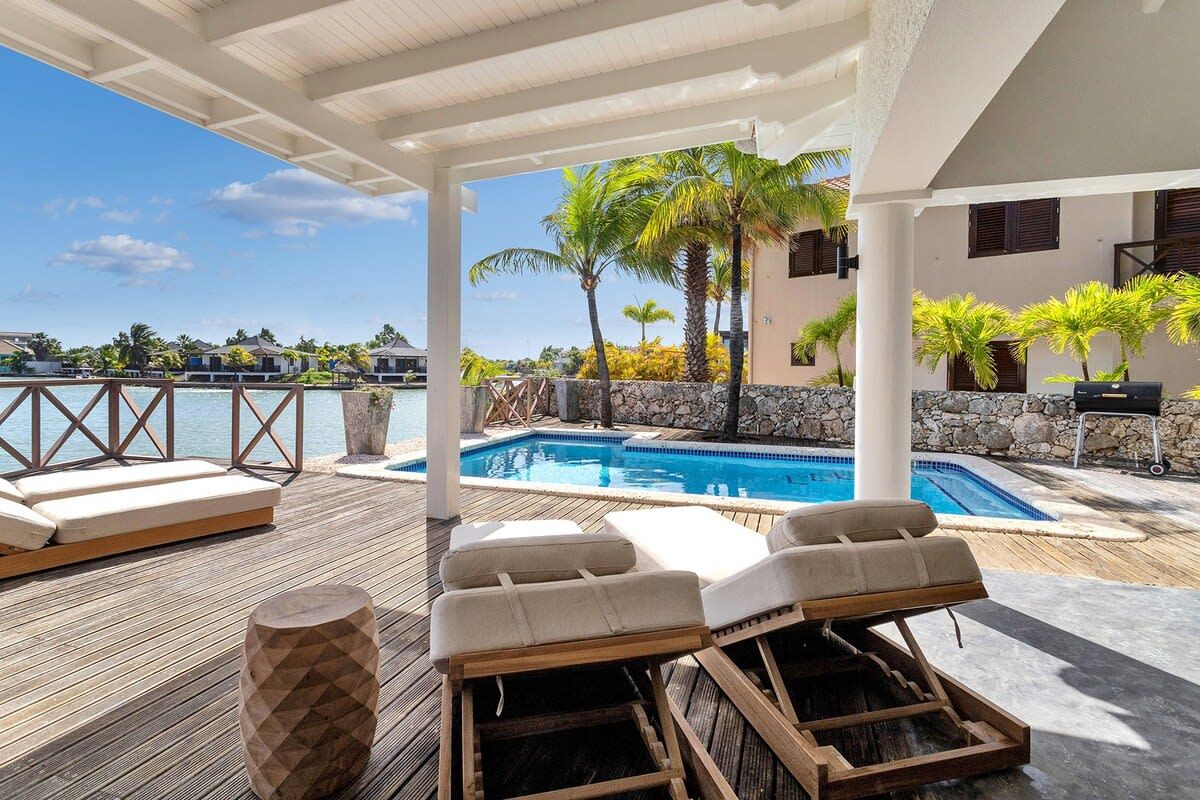 A poolside area with lounge chairs and a wooden deck.
