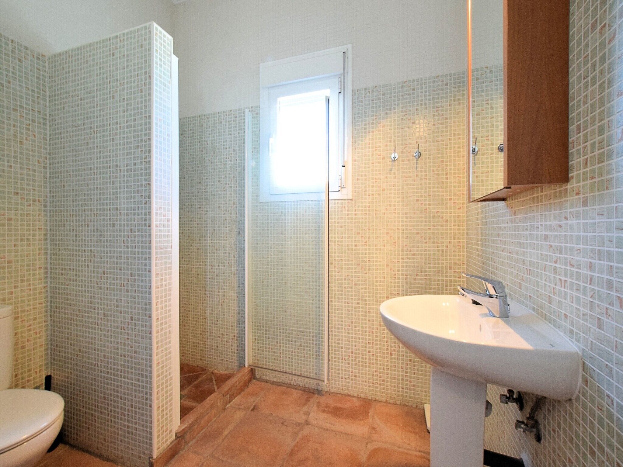 A bathroom with a toilet, a sink, and a shower.