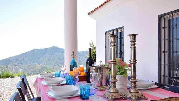 Une table dressée pour le dîner, avec vue sur un paysage montagneux.