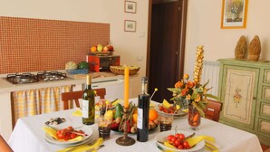 Comedor con una mesa dispuesta para dos personas, con una selección de frutas, verduras y bebidas.