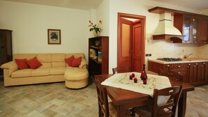 A living room with a sofa and a dining table set for four. - Farmhouse Villa w/ Pool (Cagli)