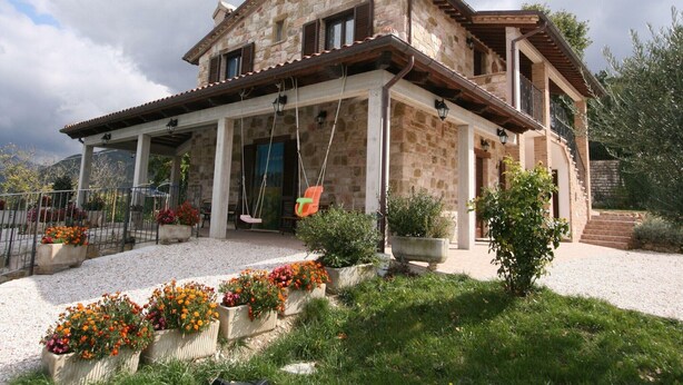 A stone house with a covered porch and outdoor seating area. - Villa in Cagli with Pool & Scenic Trails (Cagli)