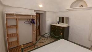 A bedroom with a bunk bed, a dresser, a mirror, and a small arched window. - Cottage in Cisternino with Garden & BBQ (Cisternino)